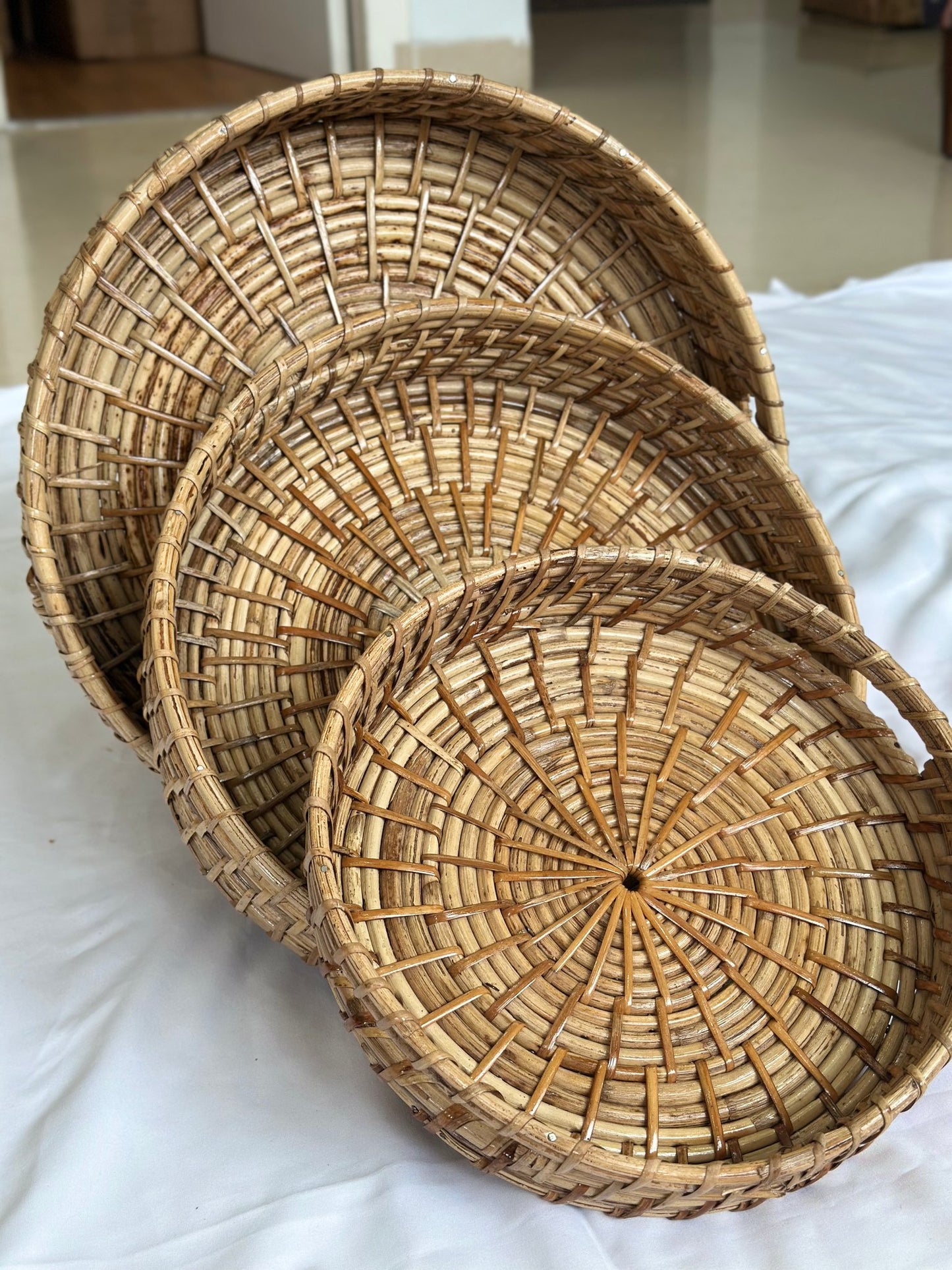 Round nesting cane tray with incut handles — handwoven in Assam, Artisan's Thread
